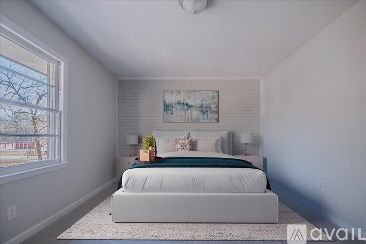 A bedroom with a large bed and a painting on the wall.
