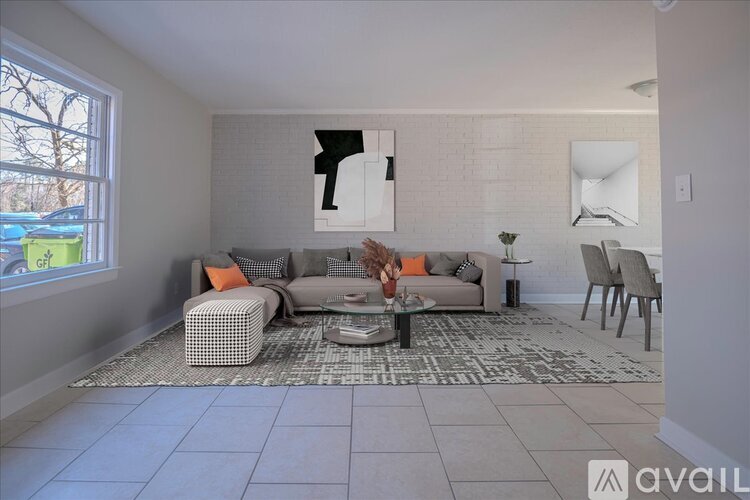 A living room with a grey couch, a coffee table, and a large abstract painting on the wall.