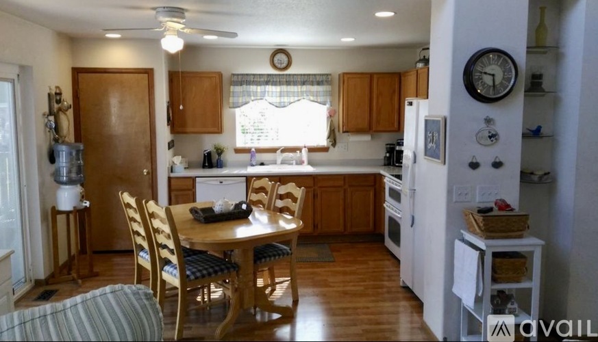 A kitchen with wooden chairs and a table with a basket on it.