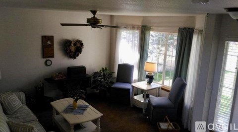 A living room with a couch, chair, and a table with a vase on it.