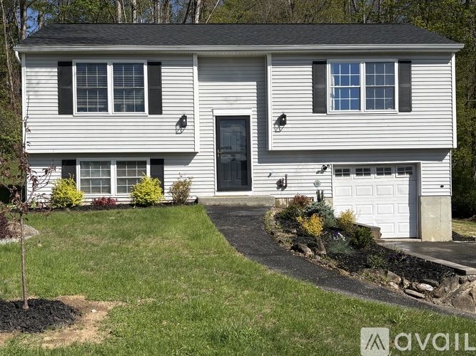 A two-story house with a garage and a front yard.
