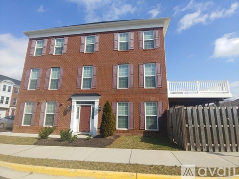 A red brick house with a white door and windows.
