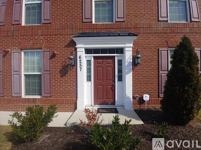 A red door with a white frame and a sign above it that says 62517.