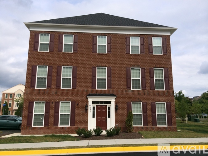 A red brick building with a white door and windows.