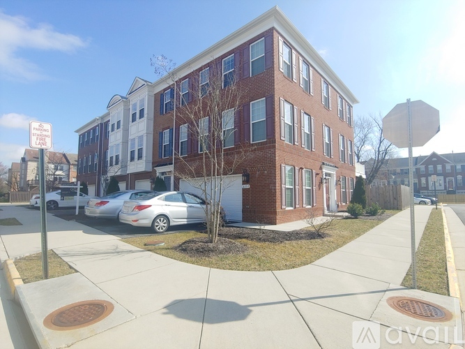 A red brick building with a white car parked in front.