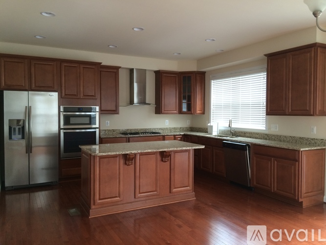 A kitchen with wooden cabinets and a marble countertop.