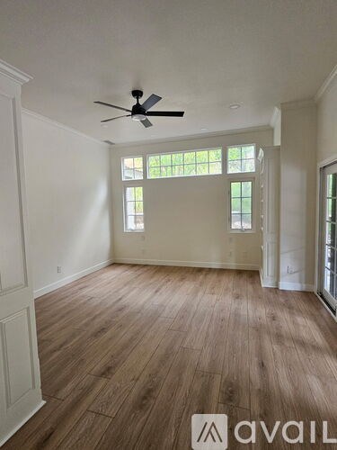 A room with wooden floors and a ceiling fan.