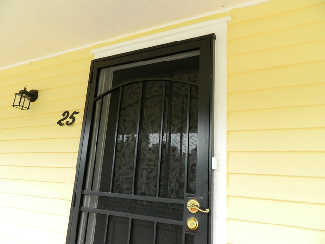 A black door with a gold handle and a number 25 on the wall above it.