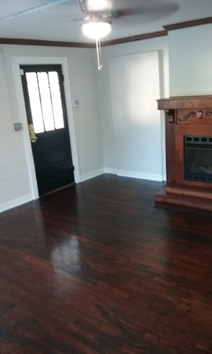 A room with a fireplace and wood floors.