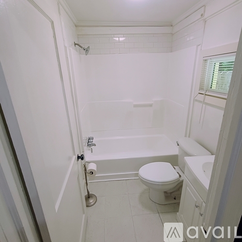 A white bathroom with a toilet, sink, and bathtub.