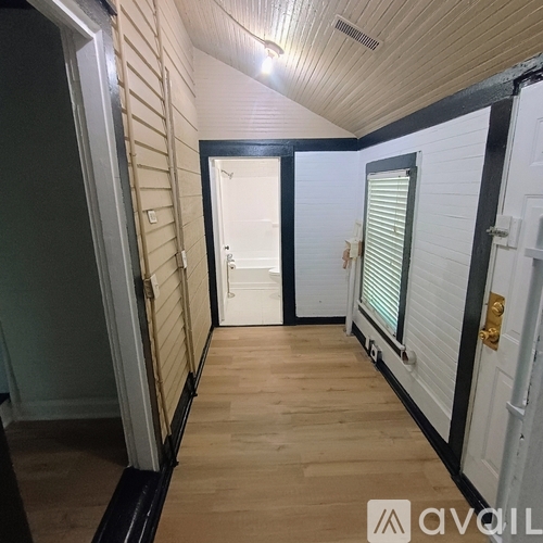A hallway with white doors and a wooden floor.