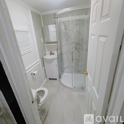 A white bathroom with a walk in shower.