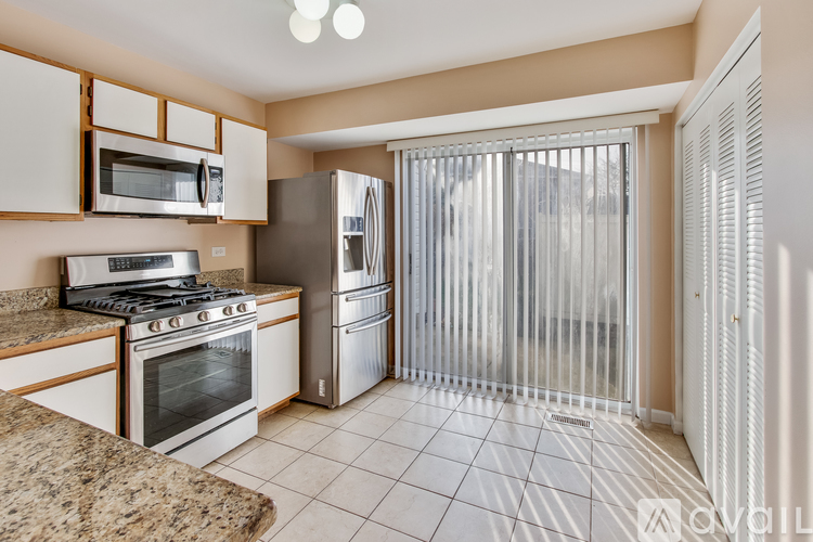 A kitchen with a stove, microwave, and refrigerator.