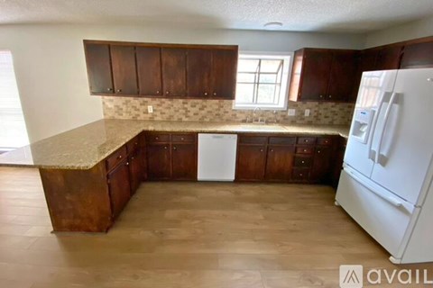 A kitchen with brown cabinets and a white refrigerator.