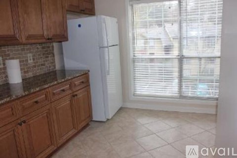 A kitchen with wooden cabinets and a white refrigerator.