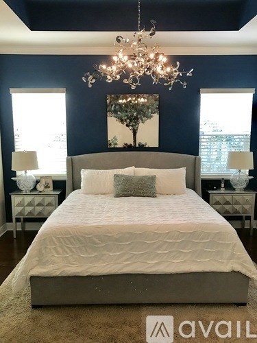A bedroom with a large bed and a chandelier.