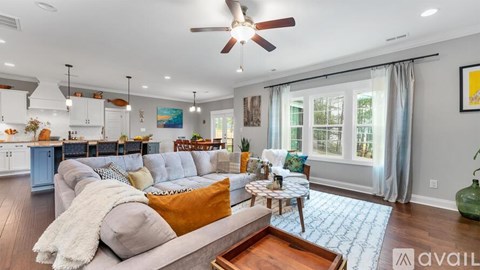 A living room with a grey couch and a ceiling fan.