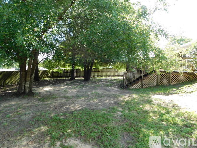 A backyard with a wooden fence and trees.