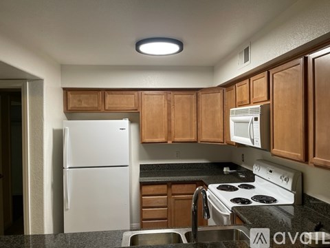 A kitchen with a white fridge and stove.