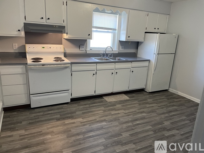 A kitchen with white appliances and cabinets.