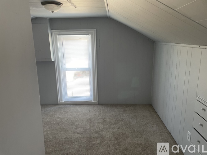 A room with a window and carpeted floor.