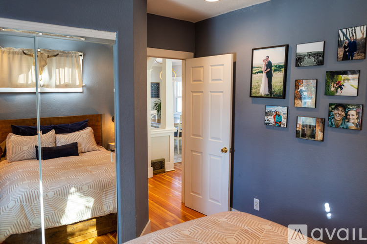 A bedroom with a large bed and pictures on the wall.