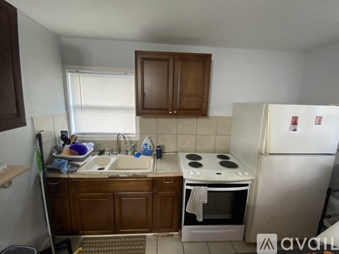 A kitchen with a white fridge, wooden cabinets, and a white stove top.