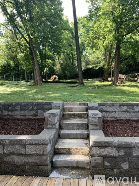 A set of stone steps lead up to a wooden deck.