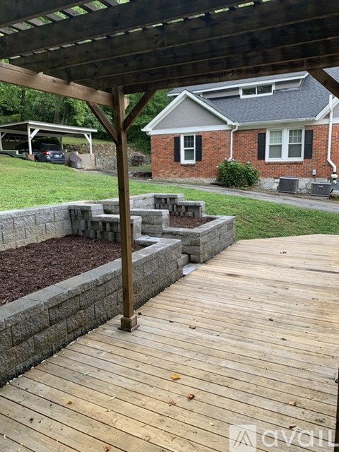 A wooden deck with a house in the background.