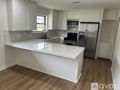 A kitchen with white cabinets and a white island.