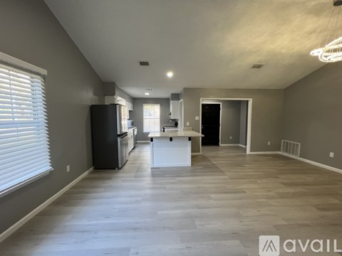 A spacious kitchen and living room with a large island in the middle.
