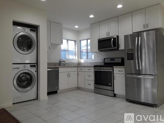 A modern kitchen with stainless steel appliances and white cabinets.