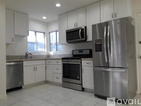 A kitchen with white cabinets and stainless steel appliances.