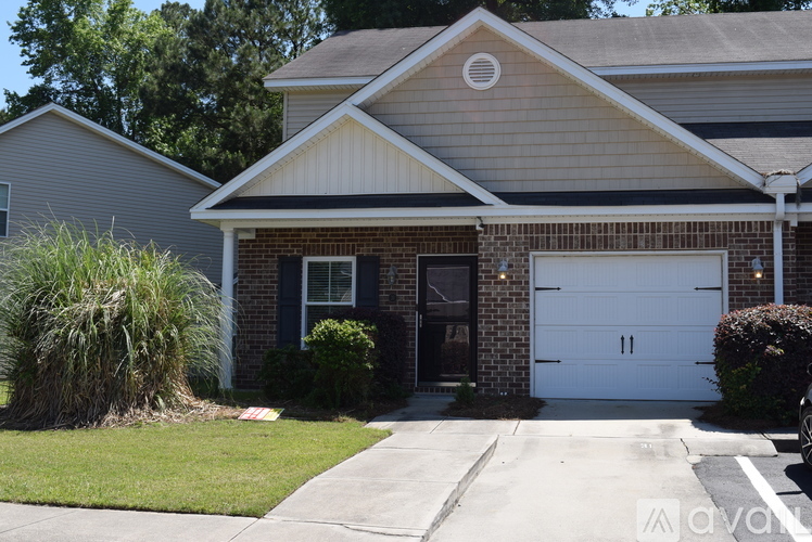A house with a white garage door and a brick facade.