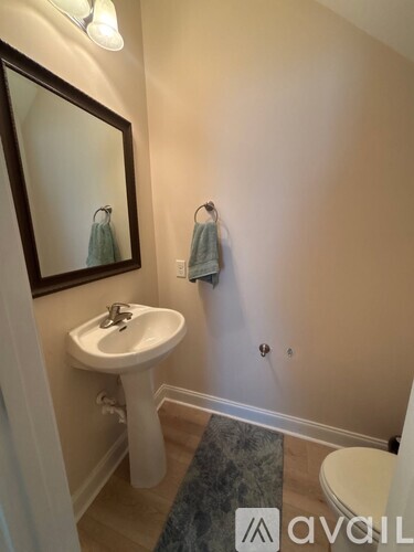 A bathroom with a sink, mirror, and towel rack.