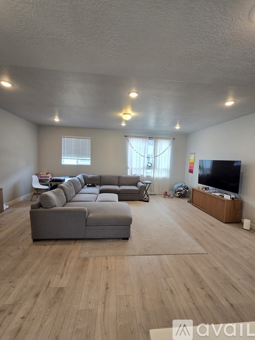A room with a carpeted floor and a window showing a house outside.