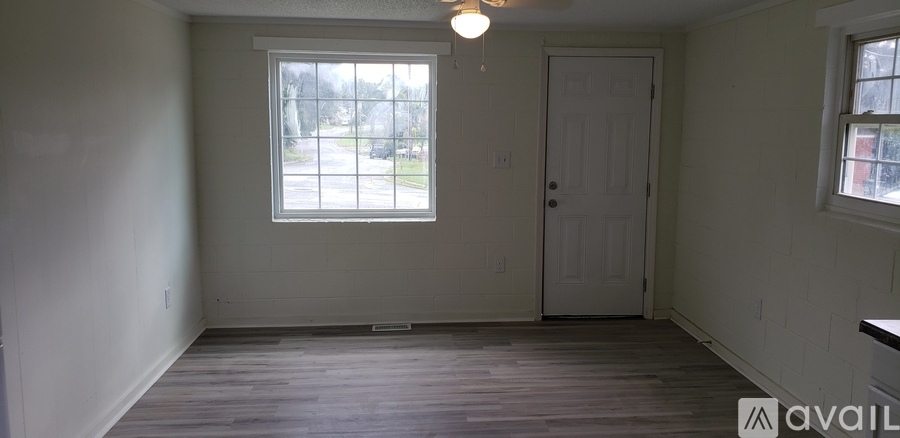 A room with a window and a door is available for rent.