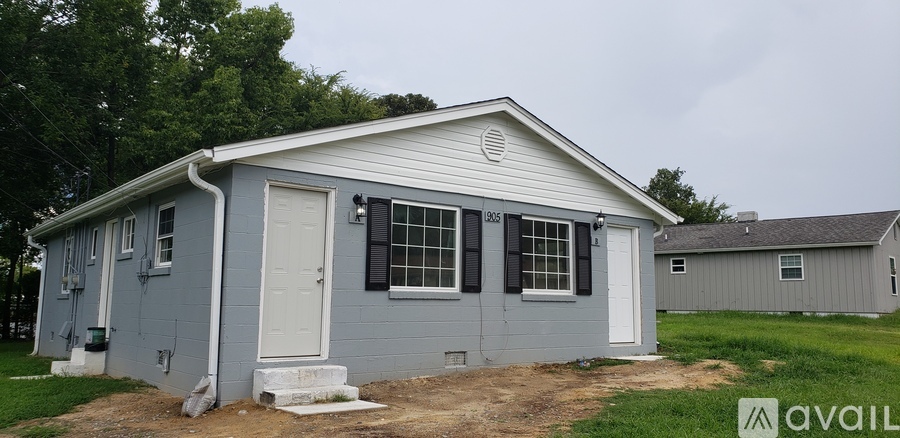 A small house with a grey exterior is available for purchase.