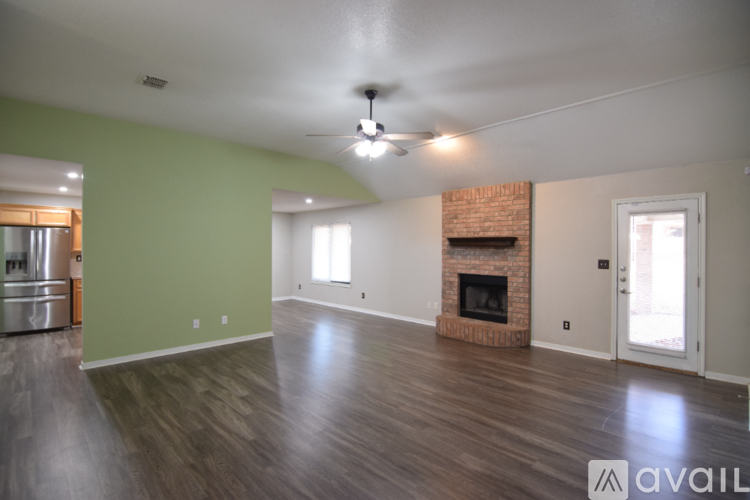 A living room with a fireplace and a ceiling fan.