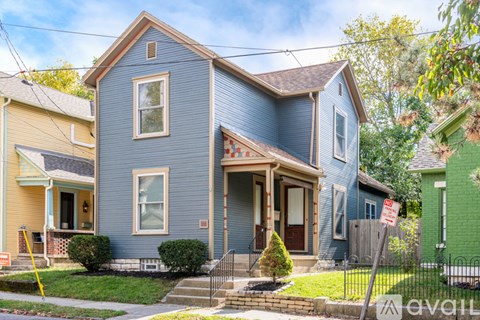 A blue house with a sign that says "available" in front of it.