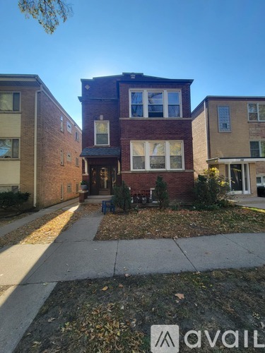 A brick house with a front yard and a sidewalk.