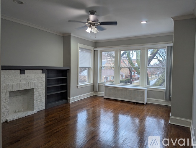 A spacious living room with a fireplace and hardwood floors.