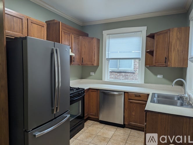 A kitchen with a black refrigerator and wooden cabinets.