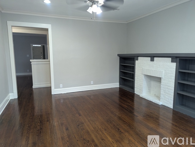 A room with a fireplace and wooden floors.