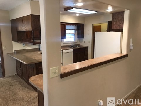 A kitchen with brown cabinets and a white refrigerator.