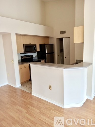 A kitchen with a white counter and a microwave on top.