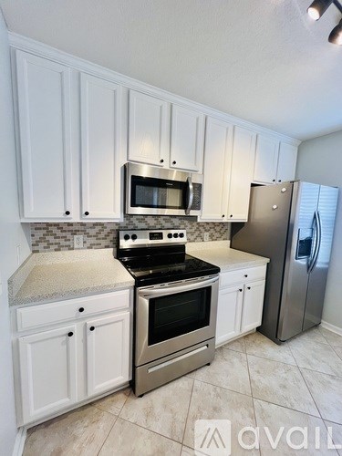 A kitchen with white cabinets and a granite countertop.