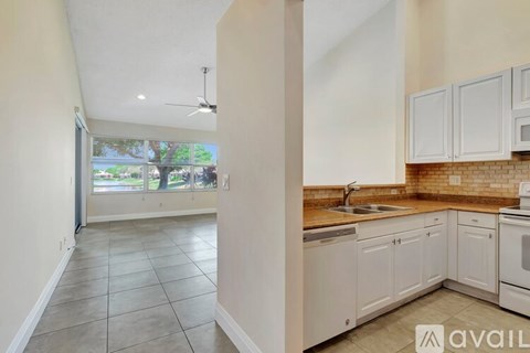 A kitchen with white cabinets and a tiled floor.