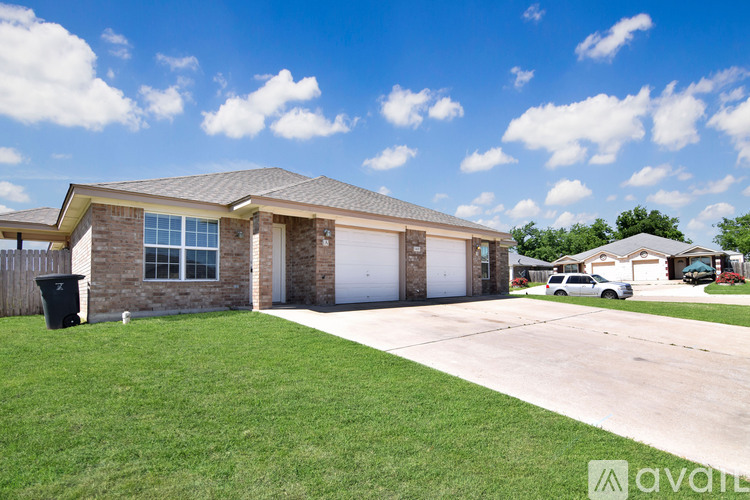 A house with a garage and a car parked in front.