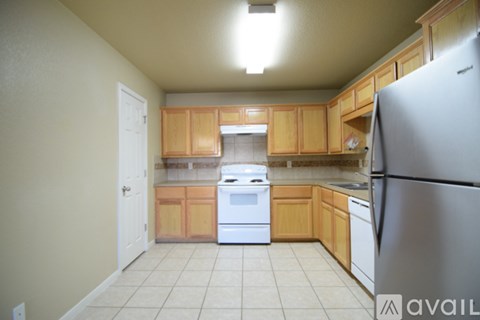 A kitchen with wooden cabinets and a white refrigerator.